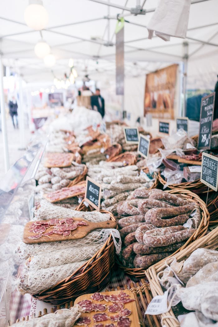Delicious assorted salami spicy sausages in handmade baskets on stall in big food market
