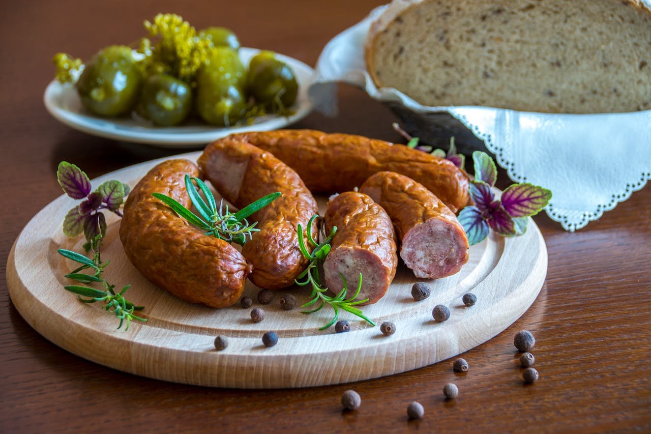 Contactar Embutidos en Huétor Tájar. Tantalizing platter of sausages with herbs, bread, and pickles.